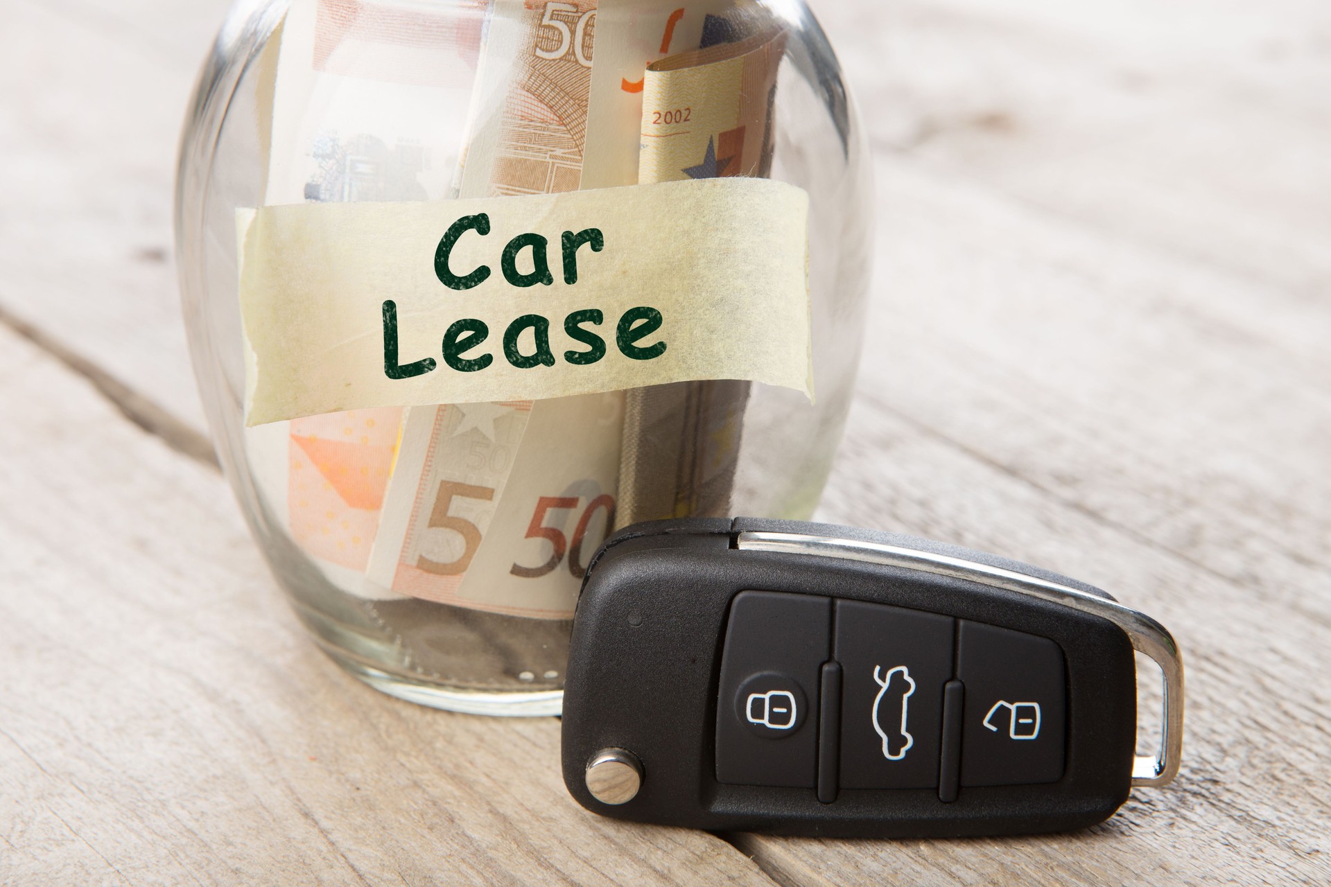 Car finance concept - money glass with word Rent, car key